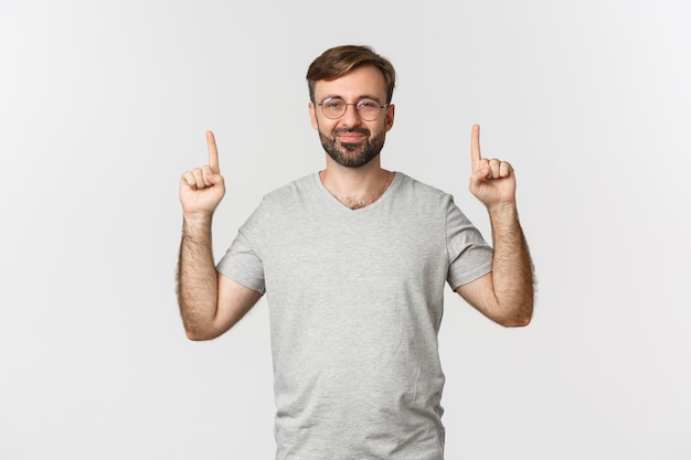 Cheerful bearded man smiling, pointing fingers up