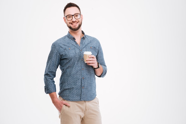 Cheerful bearded man standing with cup of coffee