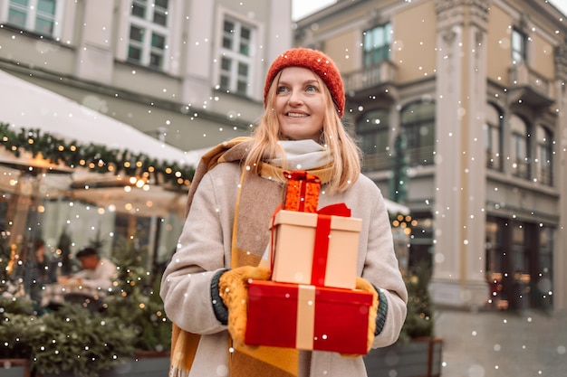 Cheerful beautiful girl hold shopping bags and present boxes in hands Winter holidays sale