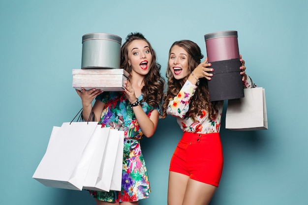 Cheerful beautiful ladies with shopping bags.