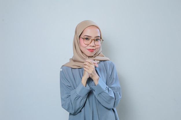 Cheerful beautiful young Asian muslim business woman wearing glasses over isolated background