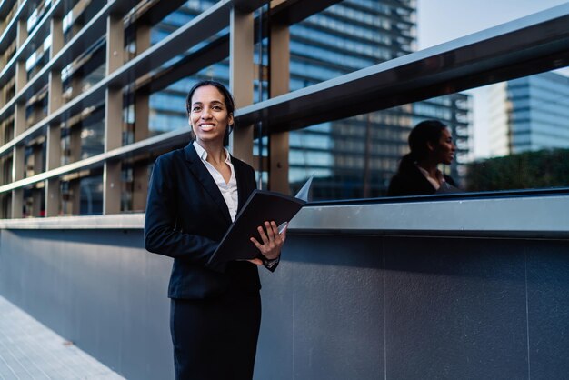 Cheerful black businesswoman with paper file