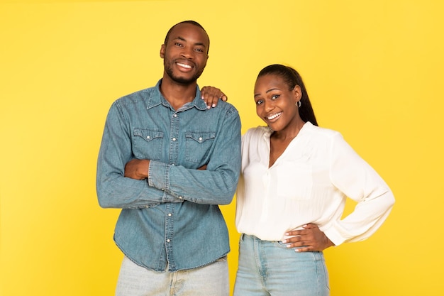 Cheerful Black Couple Posing Together Over Yellow Background