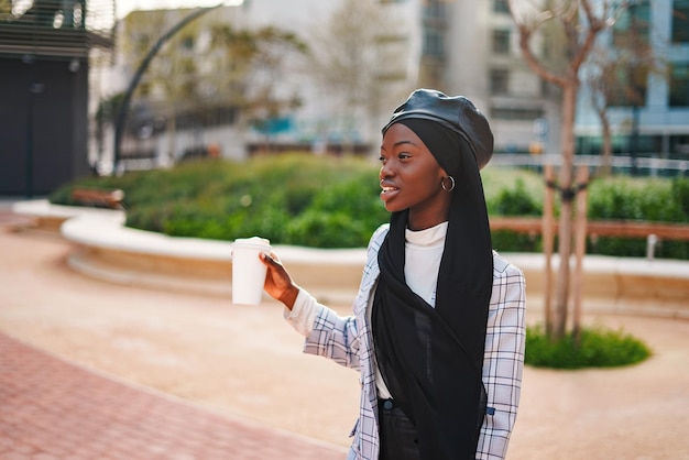 Cheerful black lady with takeaway beverage in park