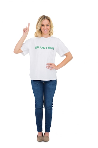 Cheerful blonde volunteer pointing up