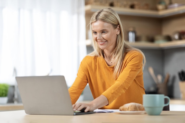 Cheerful blonde woman entrepreneur working from home