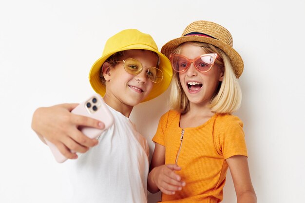 ファッショナブルなメガネの陽気な男の子と女の子の帽子selfieポーズ