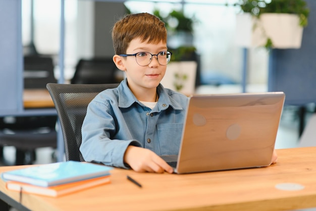 美しいスタイルでコンピューターを勉強する陽気な男の子 オンライントレーニング