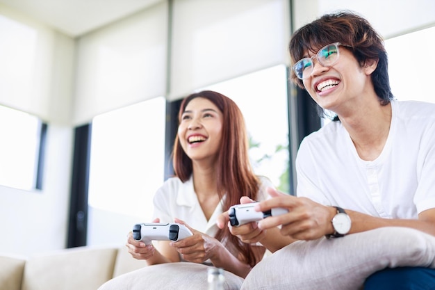 Cheerful boyfriend and girlfriend playing video game in living room People leisure activities