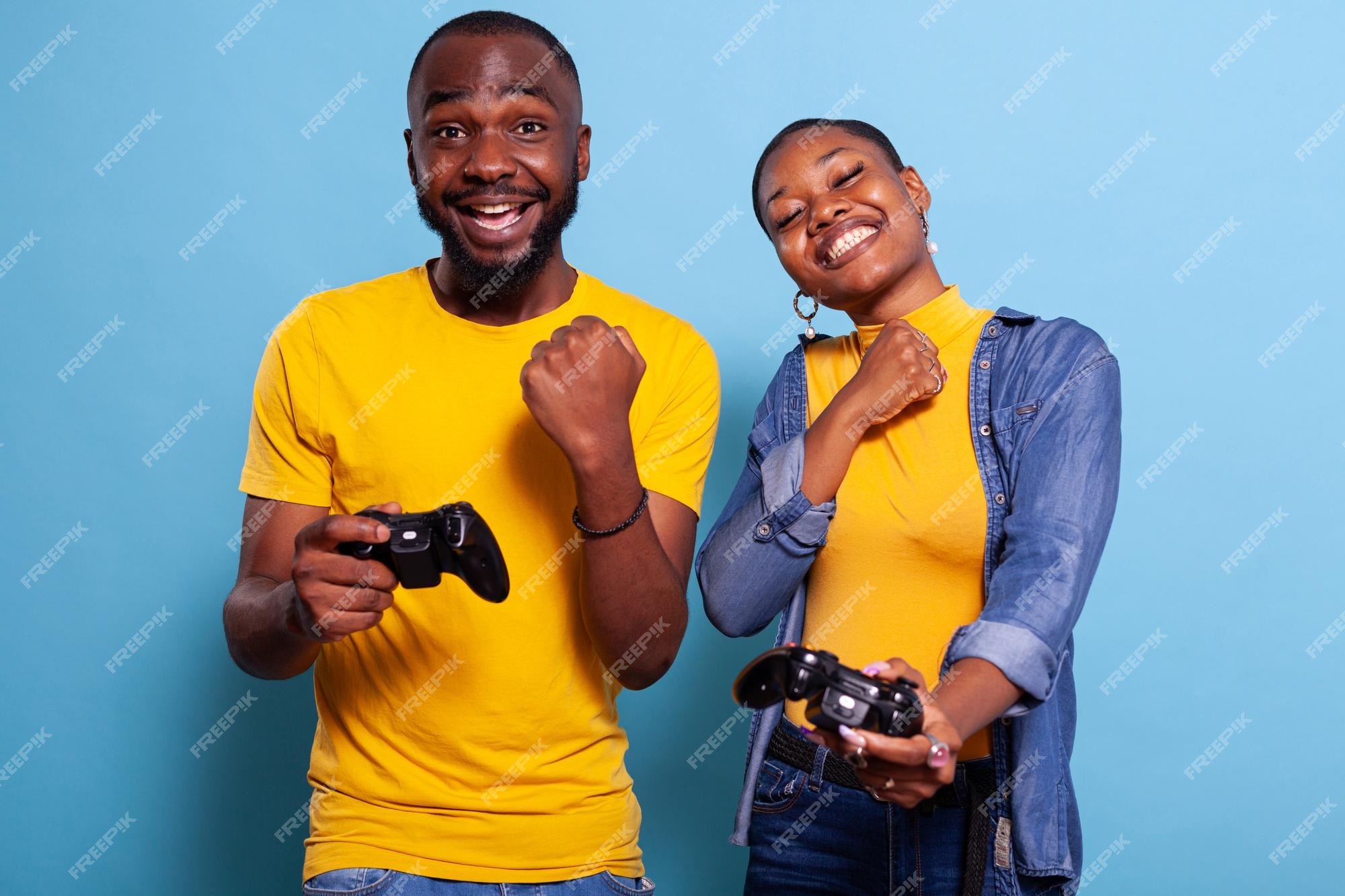 Man beating woman at video games with controller on console over blue  background. Boyfriend celebrating win and girlfriend feeling disappointed  about losing online gameplay in studio Stock Photo - Alamy