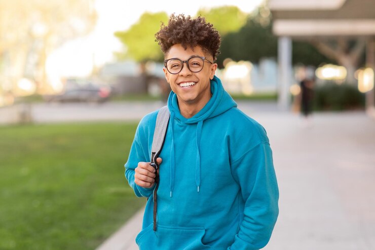 Photo cheerful brazilian student guy standing with his backpack outside