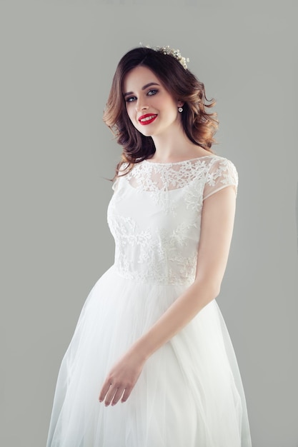 Cheerful bride woman in white wedding dress studio portrait