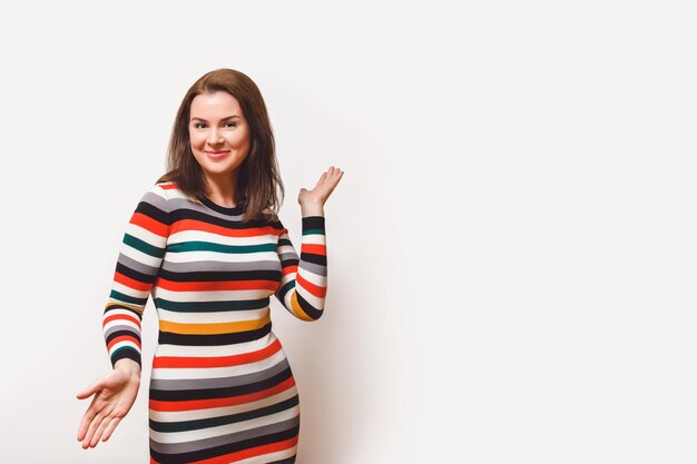 Cheerful brown-haired woman on white background showing on copy space