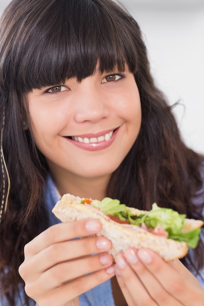 Photo cheerful brunette having a salad sandwich