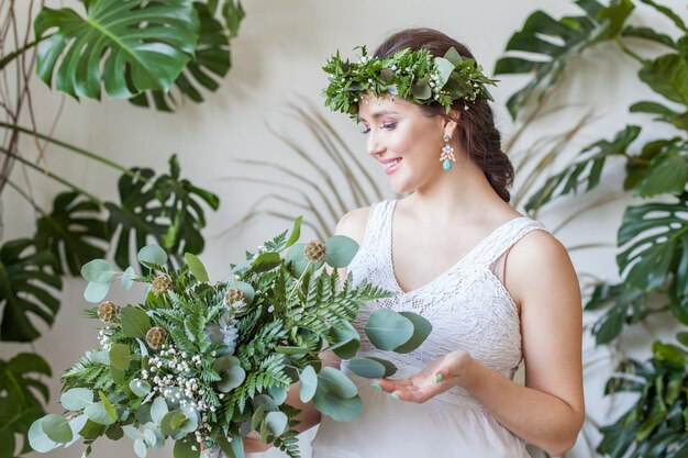 緑の葉の花束を着た陽気な茶色の妊婦