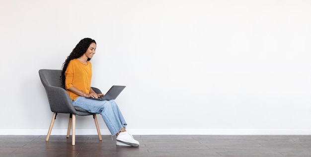 Cheerful brunette woman freelancer using laptop at home white background