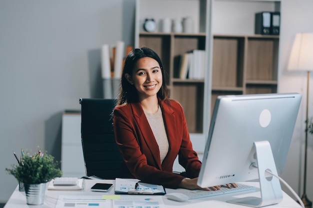 cheerful business lady working on laptop in office asian happy beautiful businesswoman in formal suit work in workplace attractive female employee office worker smile