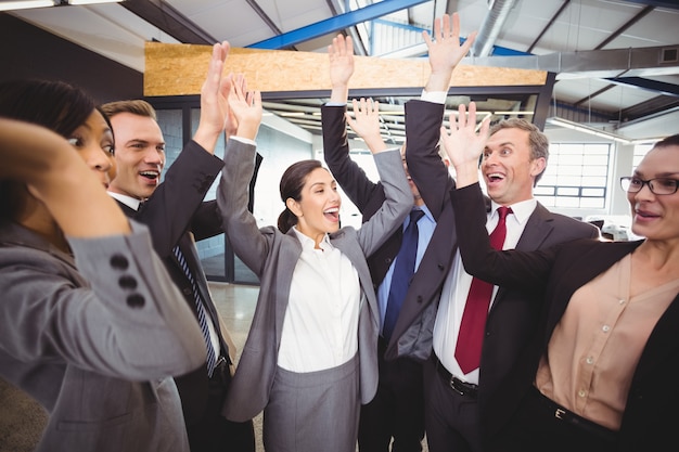 Cheerful business people raising hands