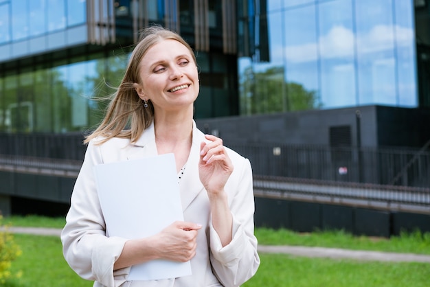 Cheerful business woman holding folder smiling middle aged businesswoman in formal attire holding do...