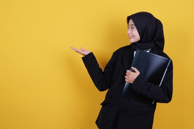 Cheerful business woman holding folders and showing something