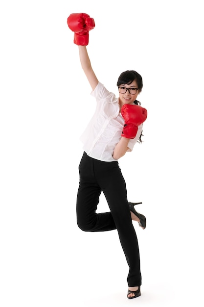 Cheerful business woman raise up hands with red boxing gloves