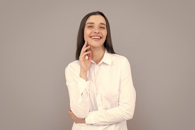 Donna d'affari allegra in camicia bianca su sfondo grigio moda