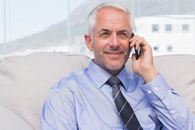 Cheerful businessman calling on smartphone