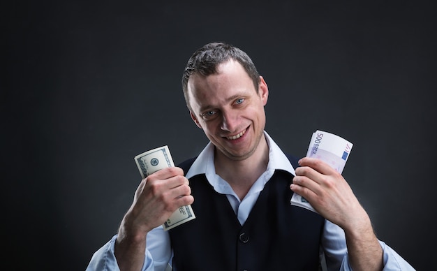 Cheerful businessman holds money in both hands