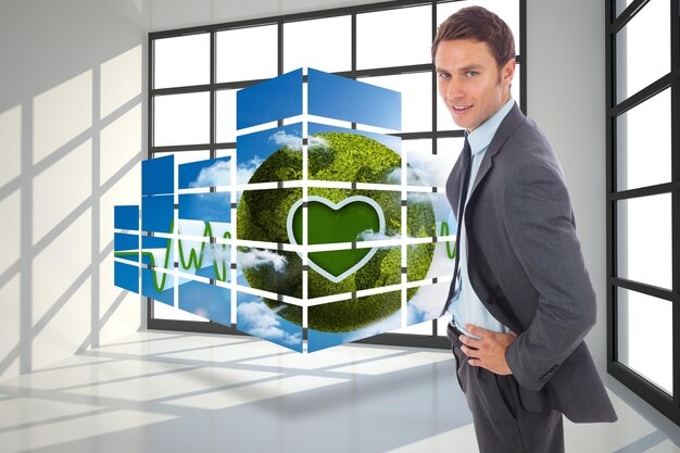 Cheerful businessman standing with hands on hips against room with a lot of windows