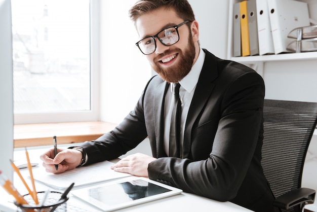 Cheerful businessman writing notes.