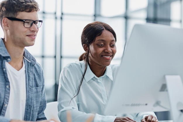 Photo cheerful businesspeople using a laptop in an office