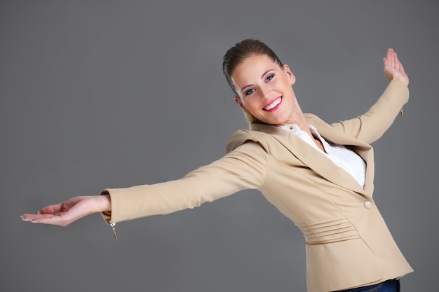 Photo cheerful businesswoman over grey background
