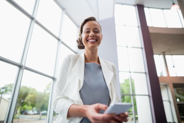 Cheerful businesswoman holding mobile phone