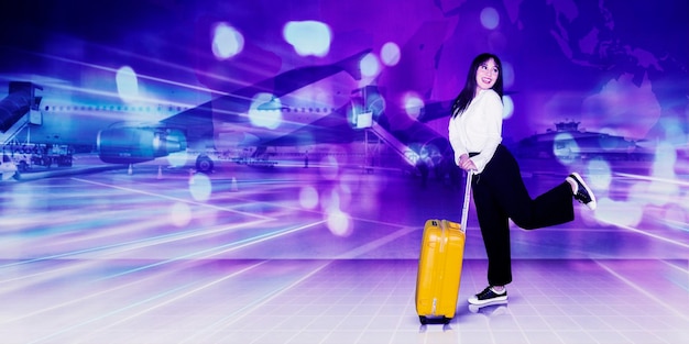 Cheerful businesswoman holds luggage in airport