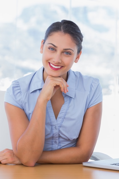 Cheerful businesswoman sitting at her desk