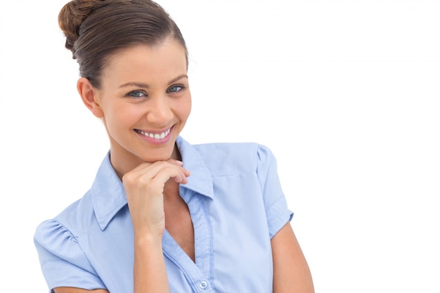 Cheerful businesswoman with hand on chin