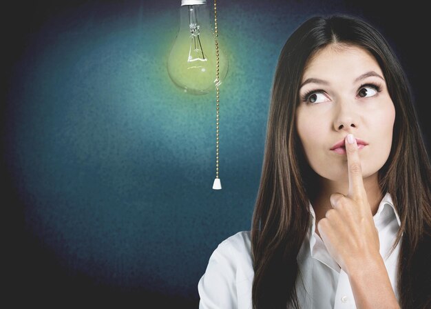 Cheerful businesswoman with idea over  background