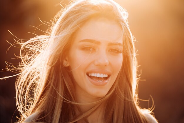 cheerful carefree woman in park on sunny autumn day