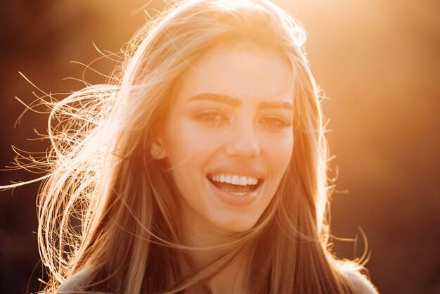 Cheerful carefree woman in park on sunny autumn day