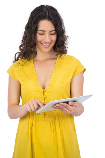 Cheerful casual young woman scrolling on her tablet computer