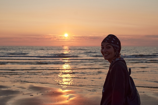 A cheerful Caucasian lady from Spain enjoying sunset at the beach