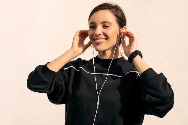 Cheerful caucasian millennial lady in sportswear and headphones enjoys fitness and jogging