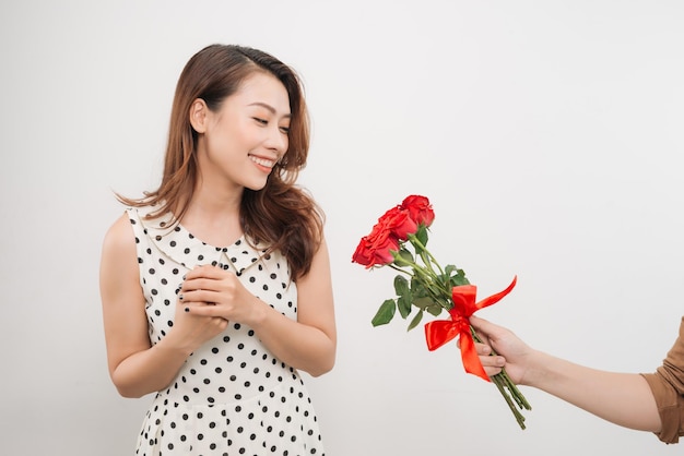 흰색 배경 위에 남자 친구로부터 꽃 다발을 받는 쾌활한 매력적인 젊은 여성
