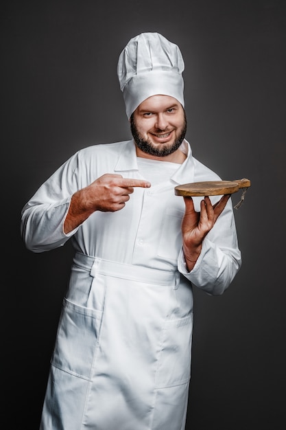 Cheerful chef pointing at empty board