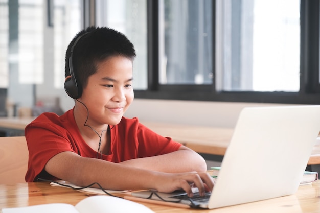 Photo cheerful child excited using computer for online learining. online education and self study and homeschooling concept.