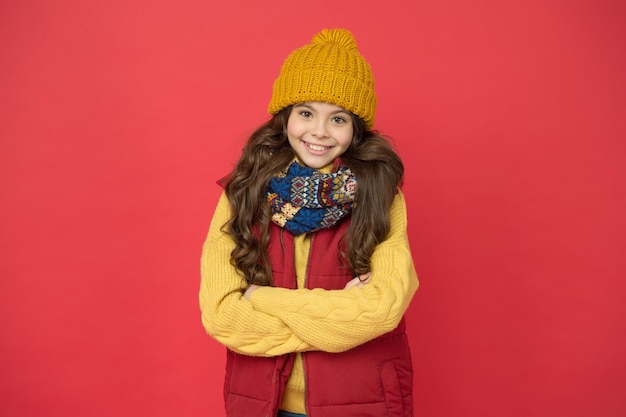 Cheerful child girl with long hair and warm clothing cozy and comfortable