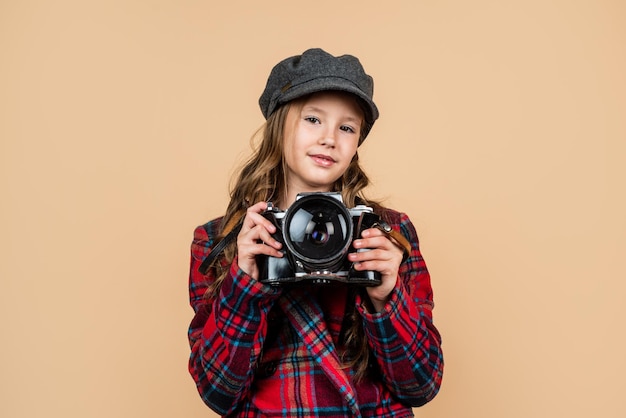 Photo cheerful child in headwear and checkered jacket use vintage camera retro photographing