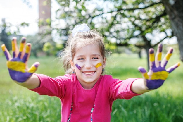 Cheerful child with hands in a paint. 