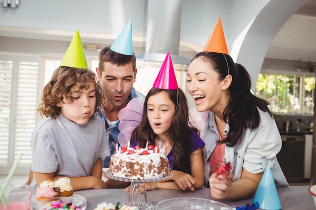 Bambini allegri che soffiano le candele sulla torta di compleanno