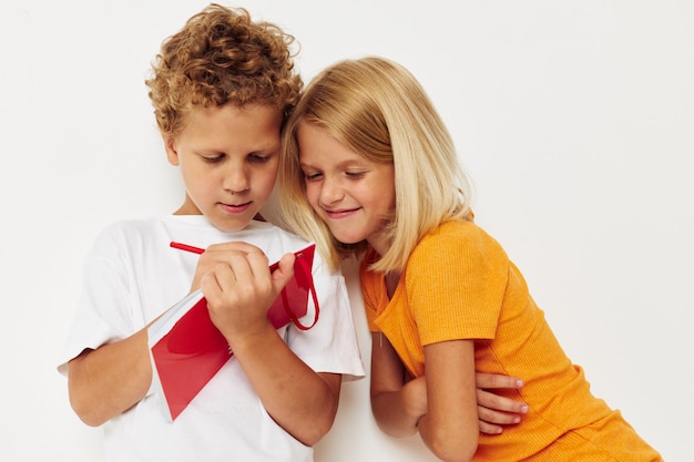 Веселые дети веселятся в красочных футболках с неизмененным фоном цвета блокнота